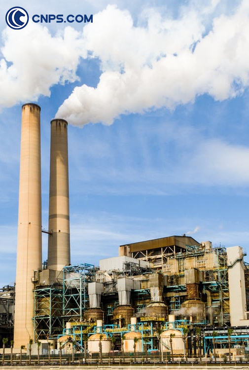 Industrial plant emissions rising against a clear sky.