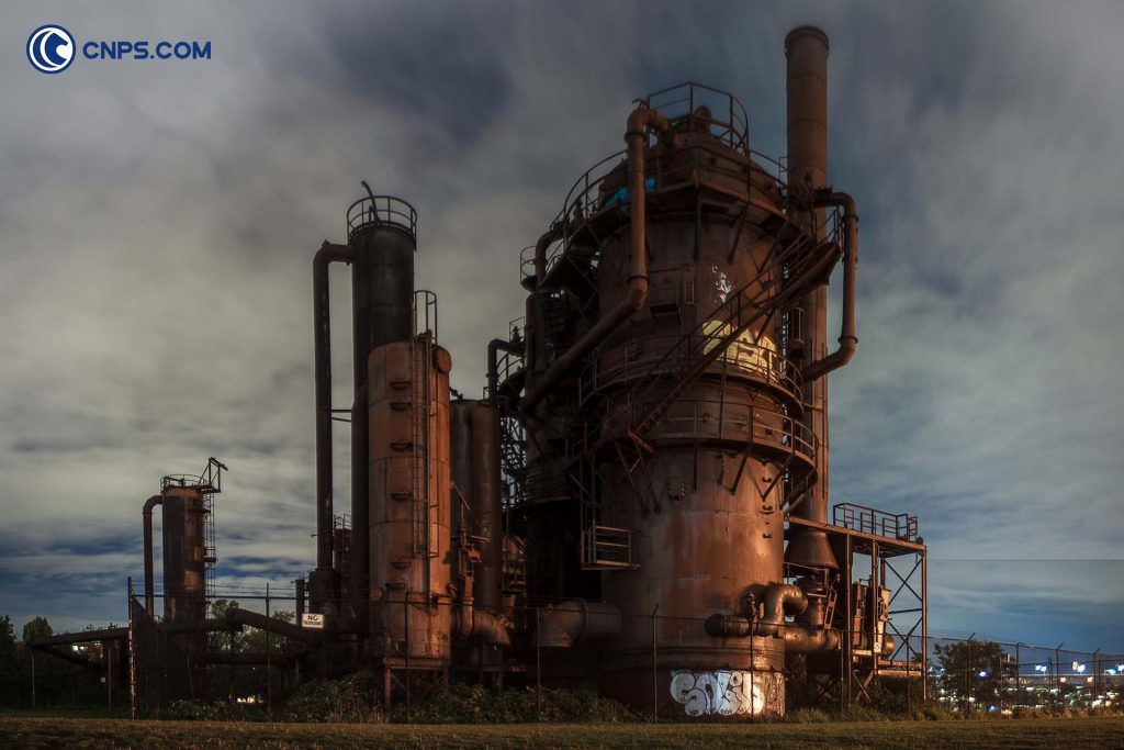 Industrial oil refinery structures at dusk.