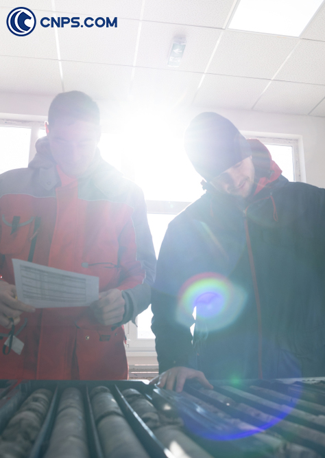 Two technicians examining core samples